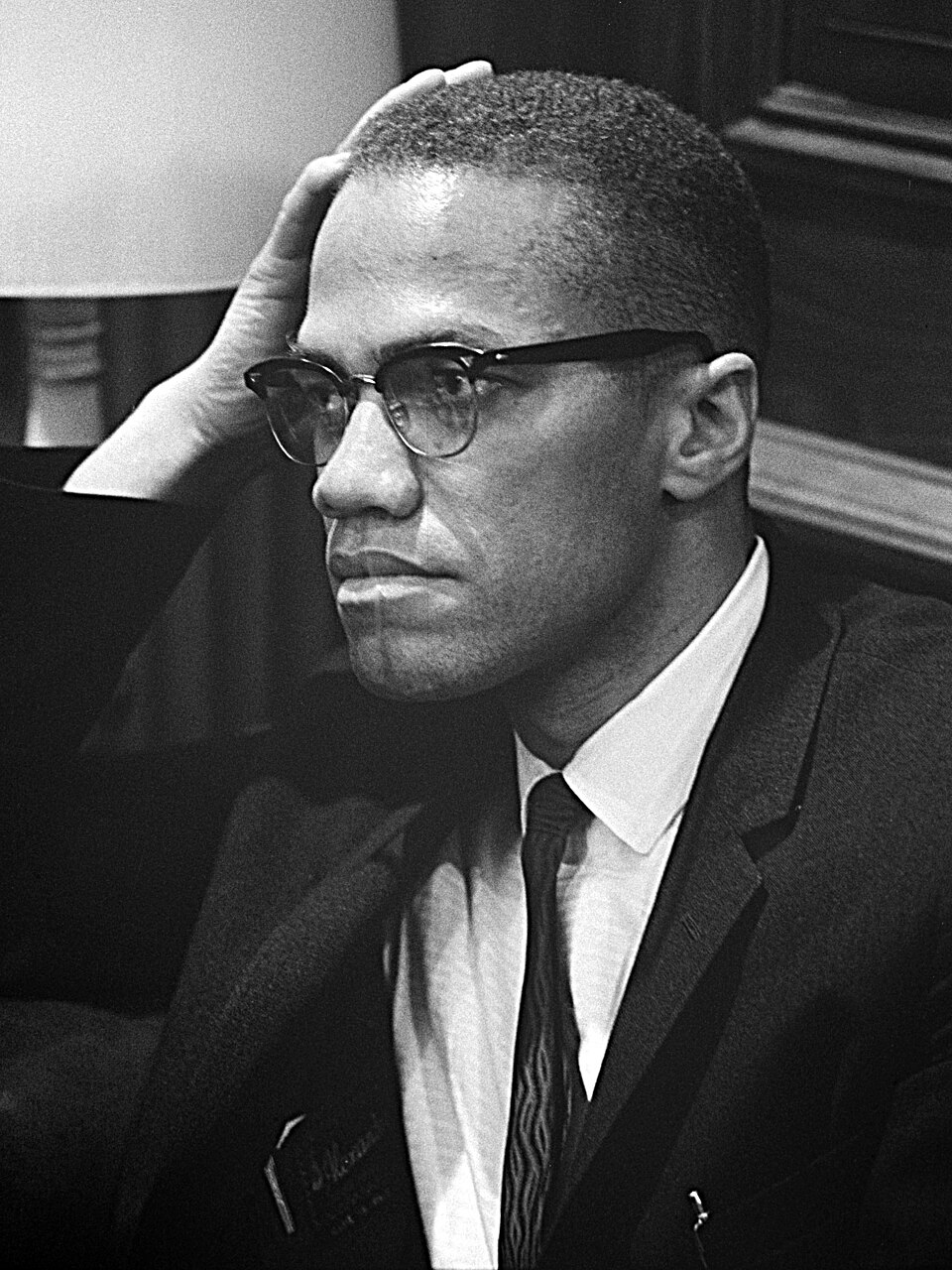Malcolm X speaking at a podium